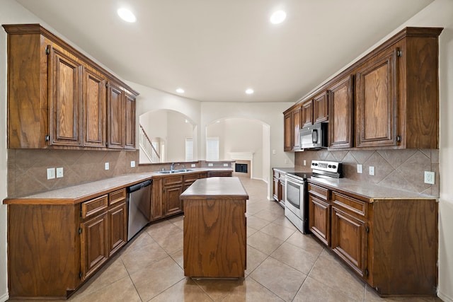 2507 Abernathy Glen Ct, Houston, TX 77014 - kitchen with stainless steel appliances, arched walkways, recessed lighting, tasteful backsplash, and a kitchen island