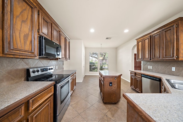 2507 Abernathy Glen Ct, Houston, TX 77014 - kitchen featuring stainless steel appliances, arched walkways, light tile patterned flooring, backsplash, and recessed lighting