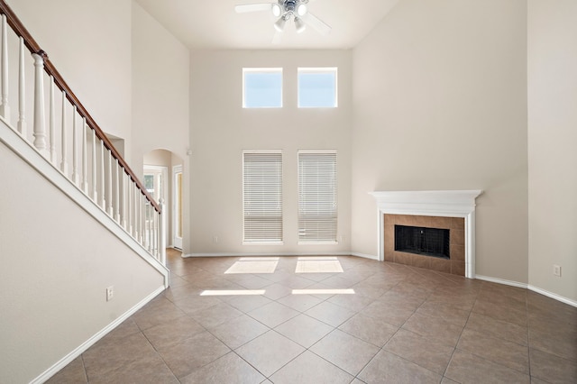 2507 Abernathy Glen Ct, Houston, TX 77014 - unfurnished living room featuring arched walkways, ceiling fan, a towering ceiling, stairway, and tile patterned floors