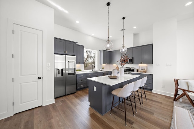 835 Rachel St Unit C, Houston, TX 77091 - kitchen with stainless steel appliances, a sink, a kitchen bar, dark wood-style floors, and a kitchen island