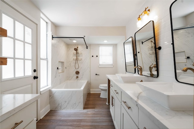 10503 Windriver Dr, Houston, TX 77070 - bathroom with double vanity, wood finished floors, toilet, and a combined bath / shower with marble appearance