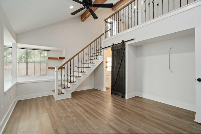 10503 Windriver Dr, Houston, TX 77070 - staircase featuring a barn door, baseboards, a ceiling fan, high vaulted ceiling, and wood finished floors
