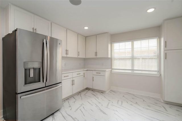 10503 Windriver Dr, Houston, TX 77070 - kitchen featuring stainless steel fridge with ice dispenser, light marble finish floors, light countertops, white cabinetry, and recessed lighting