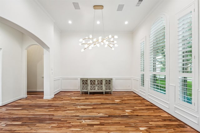 22111 Blacksburg Ct, Katy, TX 77450 - unfurnished dining area featuring wood finished floors, arched walkways, a chandelier, ornamental molding, and a wainscoted wall