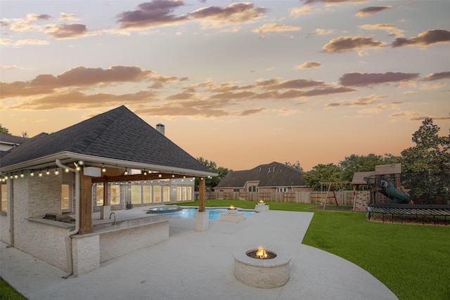22111 Blacksburg Ct, Katy, TX 77450 - pool at dusk with a fire pit, a gazebo, a playground, and a patio