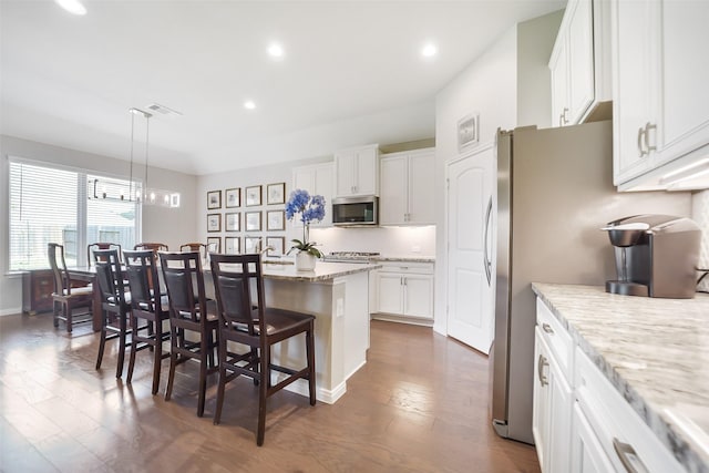 15311 Aboyne Ln, Humble, TX 77346 - kitchen with stainless steel appliances, a breakfast bar area, dark wood-type flooring, a kitchen island, and recessed lighting