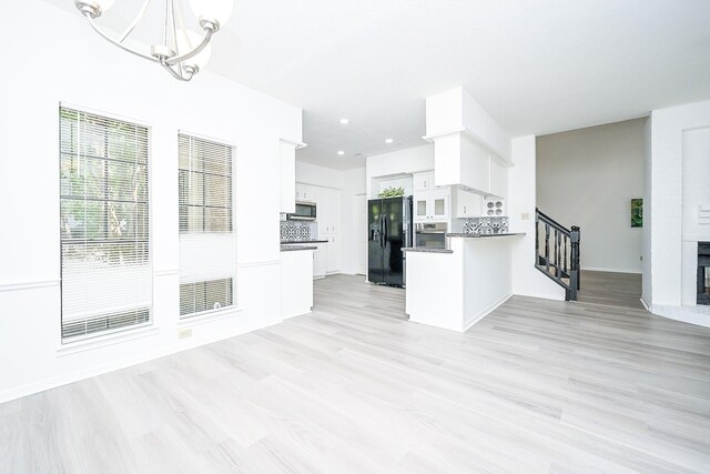 31 Silent Brook Pl, The Woodlands, TX 77381 - kitchen featuring stainless steel appliances, a chandelier, white cabinets, open floor plan, and dark countertops
