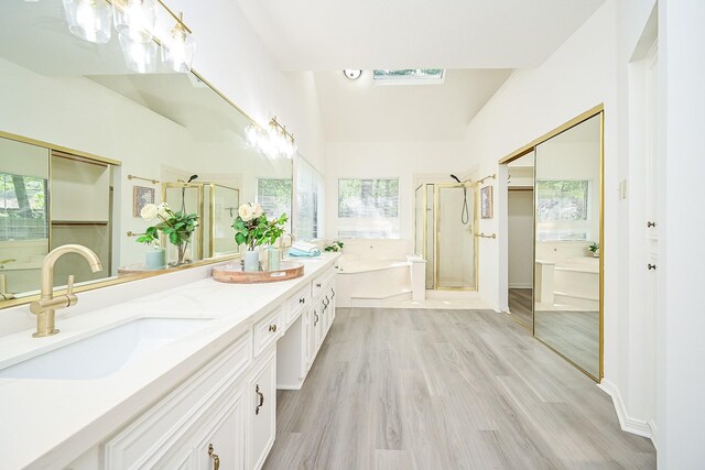 31 Silent Brook Pl, The Woodlands, TX 77381 - full bath with a garden tub, a shower stall, double vanity, a skylight, and wood finished floors