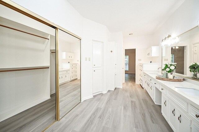 31 Silent Brook Pl, The Woodlands, TX 77381 - bathroom with double vanity, wood finished floors, and a closet