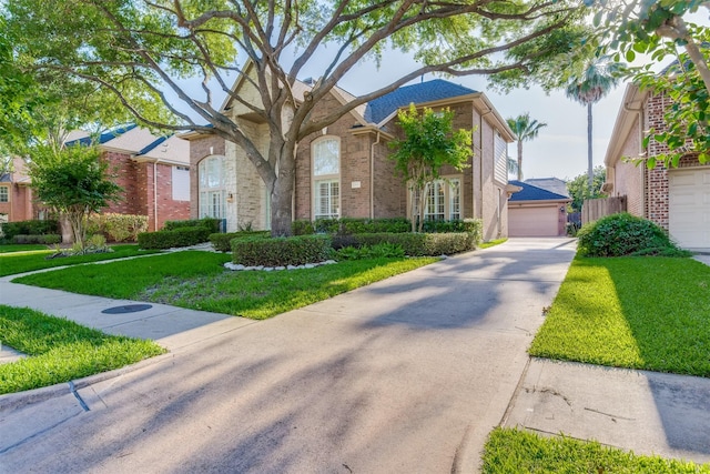 13515 N Tracewood Bnd, Houston, TX 77077 - view of front of home with brick siding, a front lawn, and a garage