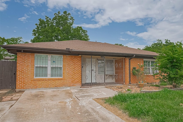 423 Gammon Dr, Houston, TX 77022 - view of front of property featuring brick siding, roof with shingles, and a patio