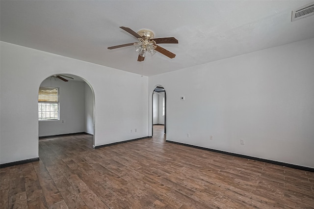 423 Gammon Dr, Houston, TX 77022 - empty room featuring arched walkways, ceiling fan, wood finished floors, and baseboards