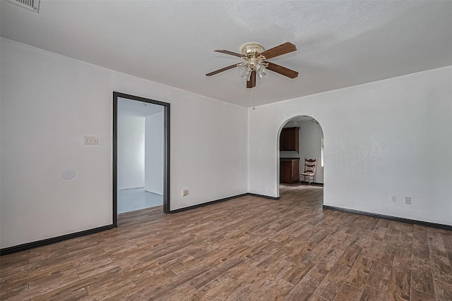 423 Gammon Dr, Houston, TX 77022 - empty room with a ceiling fan, arched walkways, wood finished floors, and baseboards