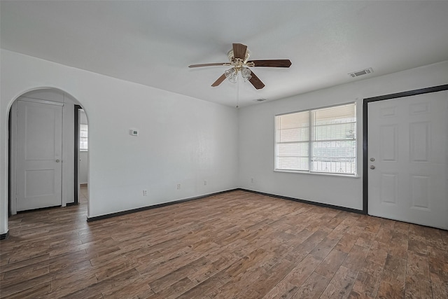 423 Gammon Dr, Houston, TX 77022 - spare room with a ceiling fan, wood finished floors, arched walkways, and baseboards