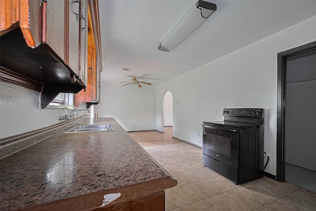 423 Gammon Dr, Houston, TX 77022 - kitchen with electric range, a sink, arched walkways, light tile patterned floors, and ceiling fan
