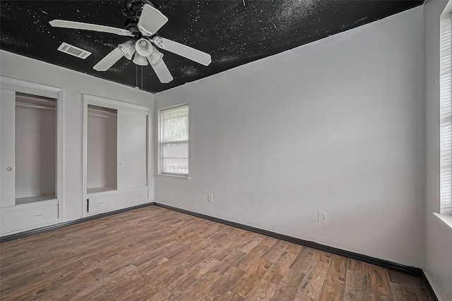 423 Gammon Dr, Houston, TX 77022 - unfurnished bedroom featuring wood finished floors, two closets, and ceiling fan