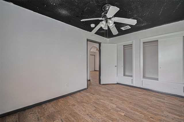 423 Gammon Dr, Houston, TX 77022 - unfurnished bedroom featuring multiple closets, wood finished floors, and a ceiling fan