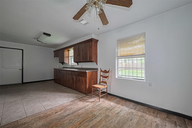 423 Gammon Dr, Houston, TX 77022 - kitchen with ceiling fan, light wood-type flooring, baseboards, dark countertops, and dark brown cabinetry