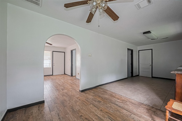 423 Gammon Dr, Houston, TX 77022 - unfurnished room featuring arched walkways, a ceiling fan, wood finished floors, and baseboards