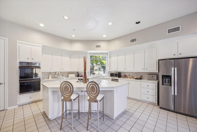 12007 Lakeway Ct, Houston, TX 77071 - kitchen featuring stainless steel appliances, a kitchen island with sink, recessed lighting, light tile patterned flooring, and white cabinets