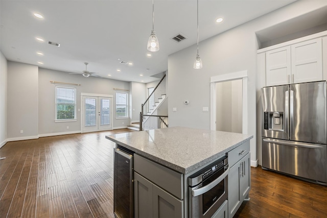 727 Schwartz St, Houston, TX 77020 - kitchen featuring appliances with stainless steel finishes, wine cooler, a ceiling fan, dark wood-style floors, and recessed lighting