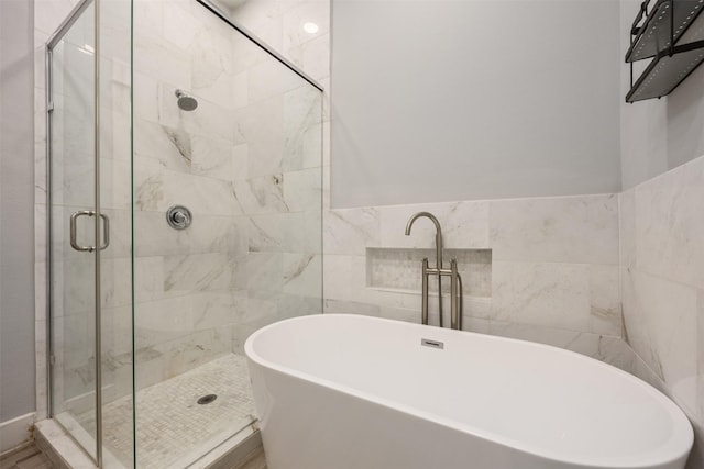 727 Schwartz St, Houston, TX 77020 - bathroom featuring a shower stall, a freestanding tub, and tile walls
