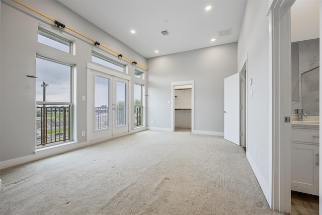 727 Schwartz St, Houston, TX 77020 - empty room with light colored carpet, recessed lighting, baseboards, a towering ceiling, and a sink