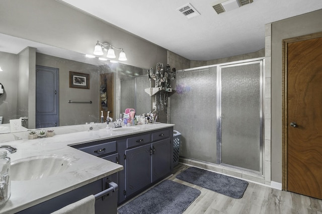 6462 US Highway 190 E, Livingston, TX 77351 - full bathroom featuring double vanity, a shower stall, and wood finished floors