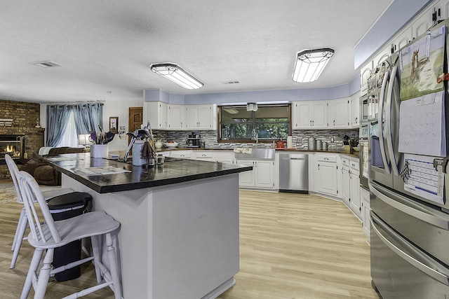6462 US Highway 190 E, Livingston, TX 77351 - kitchen featuring stainless steel appliances, a breakfast bar, a sink, decorative backsplash, and a textured ceiling