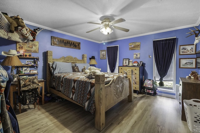 6462 US Highway 190 E, Livingston, TX 77351 - bedroom with wood finished floors, ornamental molding, a textured ceiling, and ceiling fan