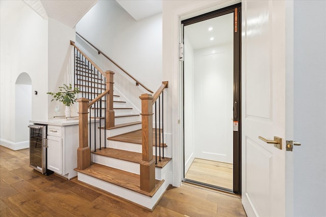 540 W 26th St Unit B, Houston, TX 77008 - stairs featuring wine cooler, arched walkways, wood finished floors, baseboards, and recessed lighting