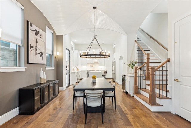 540 W 26th St Unit B, Houston, TX 77008 - dining area with stairway, a chandelier, wood finished floors, arched walkways, and baseboards