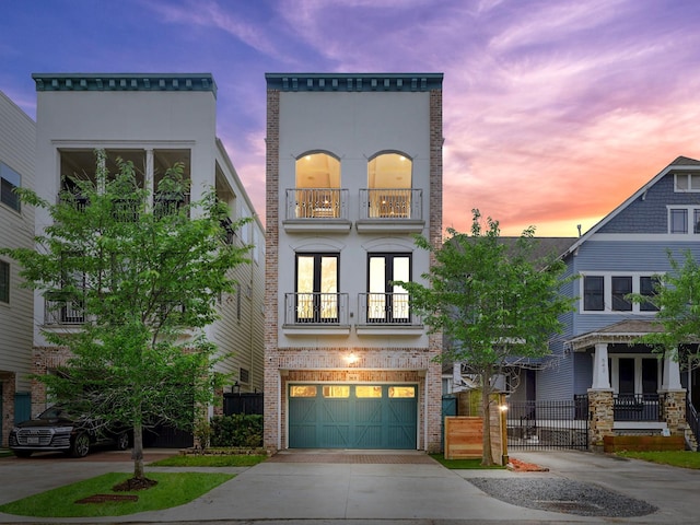 540 W 26th St Unit B, Houston, TX 77008 - view of front of house featuring french doors, driveway, brick siding, a balcony, and an attached garage