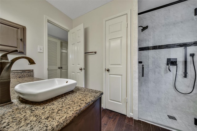 4214 Hambledon Village Dr, Houston, TX 77014 - bathroom with a stall shower, a textured ceiling, wood finished floors, and vanity