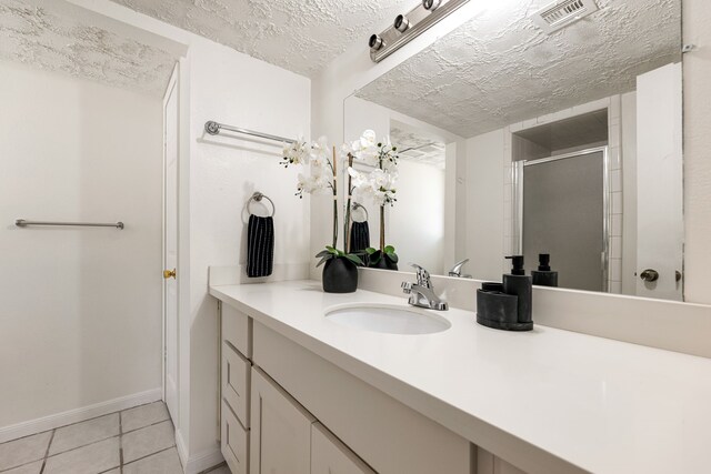 10431 Sagewillow Ln, Houston, TX 77089 - bathroom featuring vanity, a shower stall, tile patterned flooring, baseboards, and a textured ceiling
