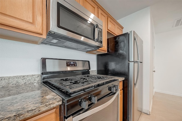 12419 Truesdell Dr, Houston, TX 77071 - kitchen with stainless steel appliances, light brown cabinets, light tile patterned floors, baseboards, and light stone countertops