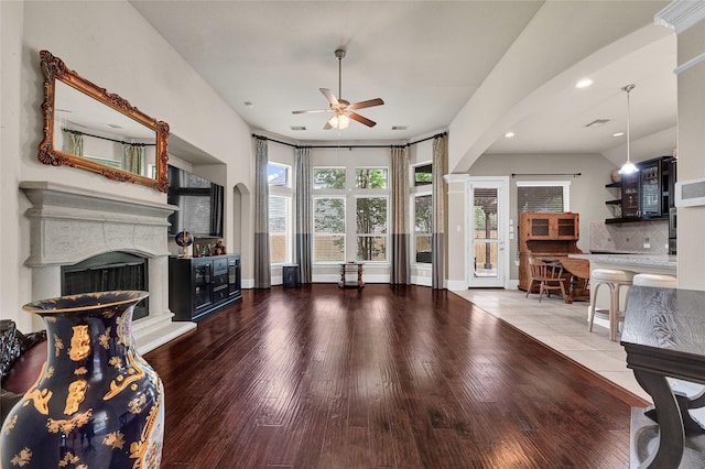 21115 Magnolia Hollow Ln, Richmond, TX 77407 - living room with ceiling fan, a fireplace, wood finished floors, recessed lighting, and arched walkways