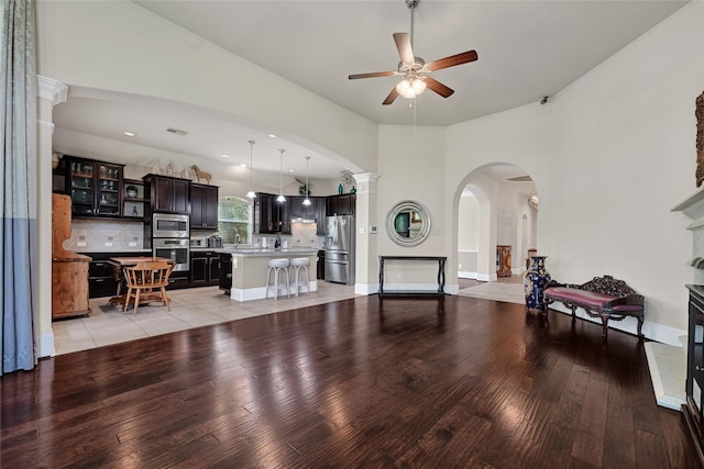 21115 Magnolia Hollow Ln, Richmond, TX 77407 - living area featuring arched walkways, light wood-style flooring, ceiling fan, and baseboards