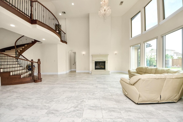 18111 Dockside Landing Dr, Cypress, TX 77433 - living room with a high ceiling, light marble finish flooring, a glass covered fireplace, a chandelier, and stairway