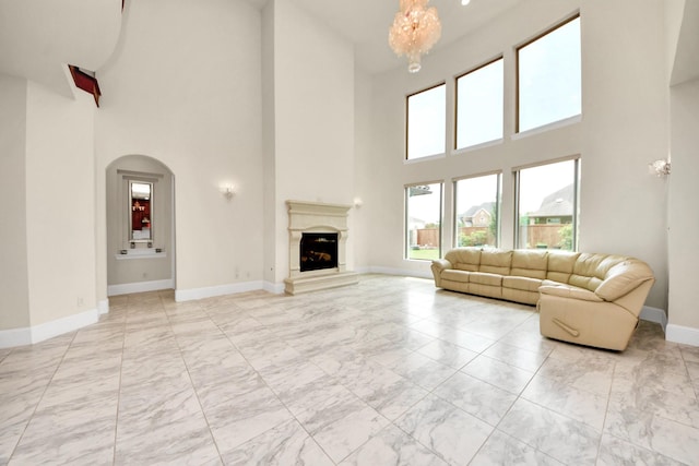 18111 Dockside Landing Dr, Cypress, TX 77433 - living area featuring light marble finish floors, a high ceiling, a chandelier, baseboards, and a fireplace with raised hearth