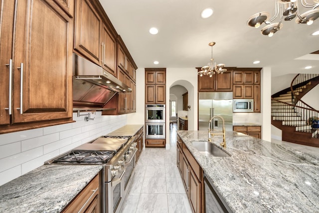 18111 Dockside Landing Dr, Cypress, TX 77433 - kitchen featuring built in appliances, a chandelier, a sink, arched walkways, and tasteful backsplash