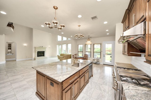 18111 Dockside Landing Dr, Cypress, TX 77433 - kitchen featuring stainless steel appliances, a sink, a chandelier, under cabinet range hood, and a glass covered fireplace