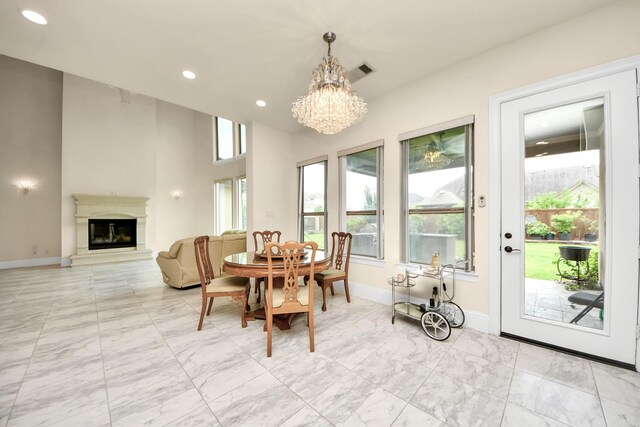 18111 Dockside Landing Dr, Cypress, TX 77433 - dining space with a chandelier, light marble finish floors, a glass covered fireplace, baseboards, and recessed lighting