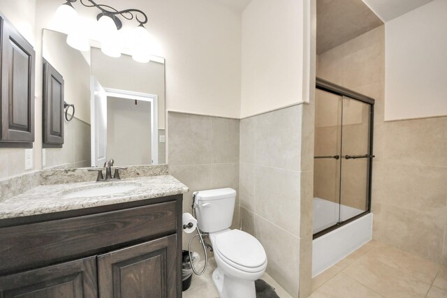 18111 Dockside Landing Dr, Cypress, TX 77433 - bathroom with tile walls, toilet, vanity, tile patterned floors, and bath / shower combo with glass door