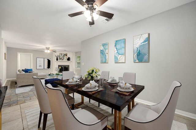 218 Chariot Ln, New Caney, TX 77357 - dining area with a ceiling fan, a fireplace, and baseboards
