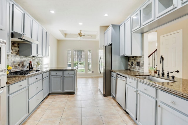 5208 Jolie Dr, Pearland, TX 77584 - kitchen with appliances with stainless steel finishes, a sink, a peninsula, under cabinet range hood, and ceiling fan