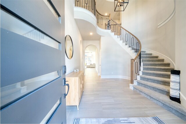 17107 Nulakeast Ct, Houston, TX 77044 - entryway featuring a high ceiling, stairway, arched walkways, baseboards, and a chandelier