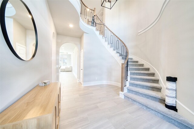 17107 Nulakeast Ct, Houston, TX 77044 - entryway featuring arched walkways, stairway, baseboards, a towering ceiling, and recessed lighting