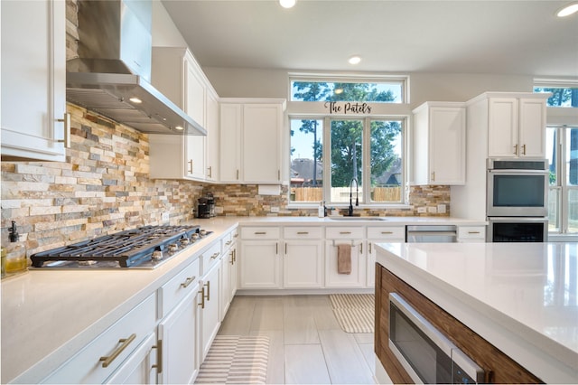 17107 Nulakeast Ct, Houston, TX 77044 - kitchen with wall chimney range hood, a sink, appliances with stainless steel finishes, white cabinetry, and recessed lighting