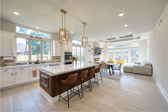 17107 Nulakeast Ct, Houston, TX 77044 - kitchen with a sink, decorative backsplash, a kitchen bar, light countertops, and stainless steel appliances